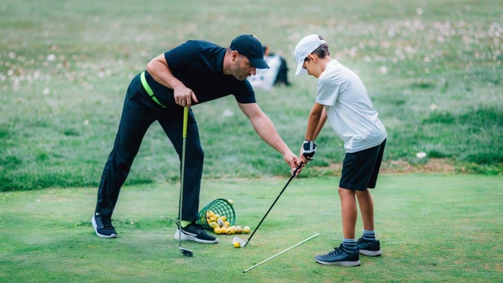 Instructeur de golf avec un jeune golfeur - Camping